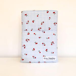 Quilted book sleeve, blue gingham padded pouch, cherry strawberry cotton cover, travel reading accessory, book club present, teacher gift