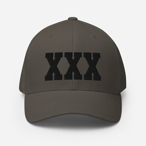 May include: A dark brown baseball cap with the word "XXX" embroidered in black on the front.