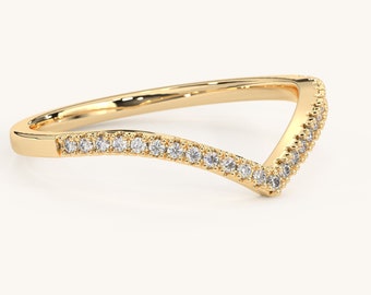May include: A gold band ring with a V-shaped design. The ring is set with small diamonds.