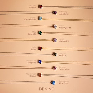 May include: A set of 12 necklaces with birthstone pendants. Each necklace features a different gemstone, representing the months of the year. The necklaces are arranged in a row, with the January pendant at the top and the December pendant at the bottom. The pendants are all small and round, and they are set in silver.