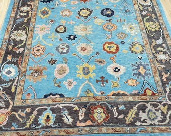 15054 – Handmade Oushak Rug 8x10 ft, Vibrant Blue Wool Area Rug with Brown Border and Colorful Tribal Floral Motifs, Turkish Carpet
