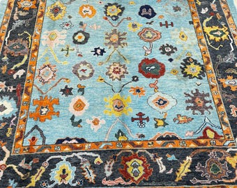 12085 – Handmade Oushak Rug 8x10 ft, Aqua Blue Wool Area Rug with Bold Black & Orange Border and Multicolor Floral Design