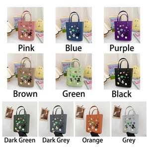May include: A collection of small tote bags in various colors: pink, blue, purple, brown, green, black, dark green, dark grey, orange, and grey. Each bag has a pair of handles and is decorated with cartoon character embellishments. The word "Pink", "Blue", "Purple", "Brown", "Green", "Black", "Dark Green", "Dark Grey", "Orange", and "Grey" are written below each bag.