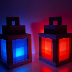 May include: Two Minecraft-style lanterns, one with a blue light and one with a red light. The lanterns are made of wood and have a square shape.