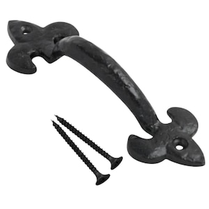 May include: A black metal door handle with a textured finish and a fleur-de-lis design at each end. The handle features two pre-drilled mounting holes, one at each end, and is accompanied by two matching black metal screws for installation.