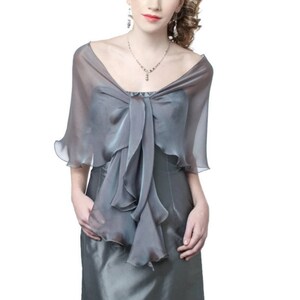 May include: A grey sheer shawl with a ruffled trim and a bow at the neck. The shawl is made of a lightweight fabric and is perfect for adding a touch of elegance to any outfit.
