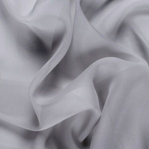 May include: A close-up of a light gray sheer fabric with soft folds and wrinkles.