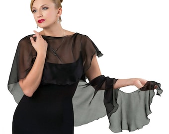 May include: A black sheer shawl with ruffled edges. The shawl is draped over a woman's shoulders and is worn over a black dress.