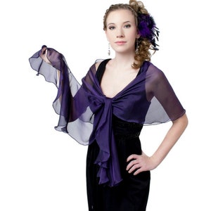 May include: A purple chiffon shawl with ruffled edges. The shawl is draped over the shoulders of a person wearing a black dress.