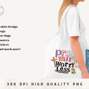 May include: A white tote bag with the words "Pray More Worry Less" in a colorful collage design. The bag also features a wooden cross, a peace sign, and a praying hands graphic. The bag is being carried by a person.