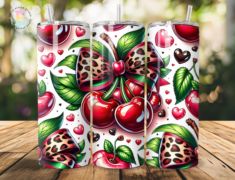 Puede incluir: Tres vasos de acero inoxidable con un dise&ntilde;o de cerezas. El dise&ntilde;o presenta cerezas rojas brillantes, hojas verdes y un lazo con estampado de leopardo. Acentos de coraz&oacute;n rosa y negro est&aacute;n dispersos sobre el fondo blanco.