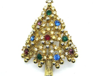May include: A gold-tone Christmas tree brooch with clear, red, blue, green, and purple rhinestones.