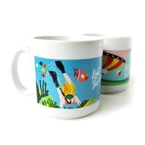 以下が含まれることがあります： カラフルなデザインが施された白いセラミック製のマグカップが2つ。1つのマグカップには、青い海のシーンにサンゴと魚が描かれており、フィンとシュノーケルをつけたダイバーが描かれています。もう1つのマグカップには、赤、黄、青のストライプの熱気球が描かれています。両方のマグカップには「Knit The One」という文字が書かれています。