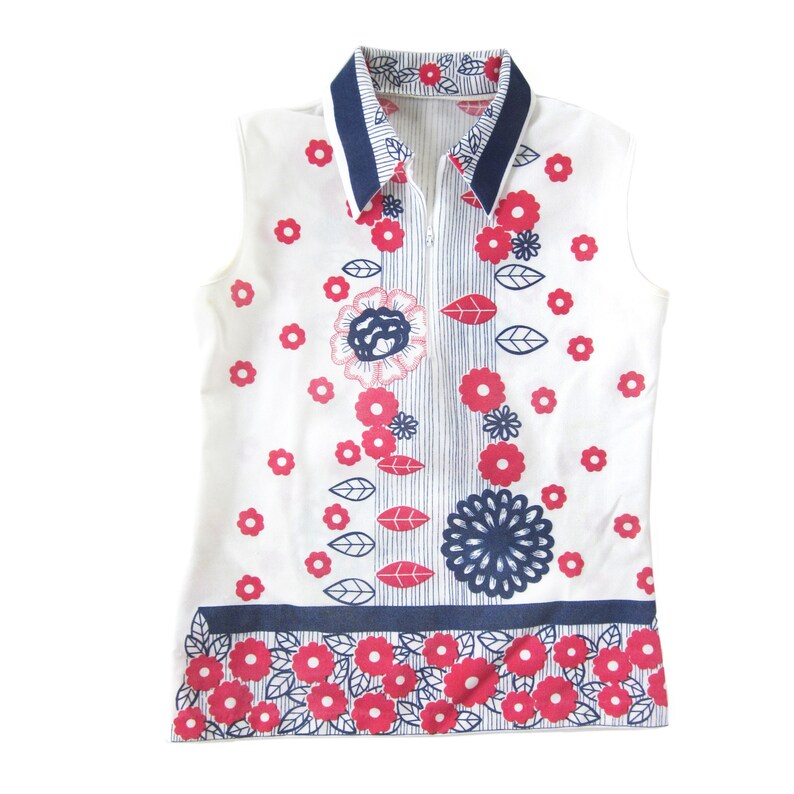 May include: A sleeveless white collared shirt with a blue and white striped collar and a zipper closure. The shirt has a floral pattern with pink and blue flowers and leaves.