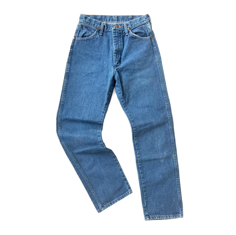 May include: A pair of classic blue denim jeans. The jeans have a straight leg cut, a button and zipper closure, and five pockets. The denim is a medium wash, and the jeans appear to be new or in excellent condition.