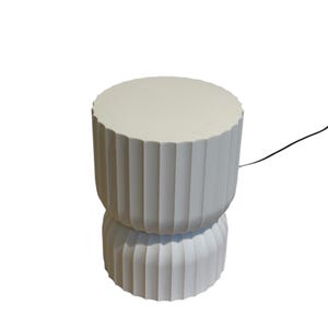 Full view of a modern table lamp, turned off, with a white background. Inspired by Japanese rice paper lamps, it emits a warm, diffused light, highlighting its minimalist design and soft ambient glow.