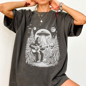 Big Foot & Alien Gitarren Jam T-Shirt | Lustiges UFO Sasquatch Tee, Space Cryptid Liebhaber Geschenk | Kosmische Camping Vibes