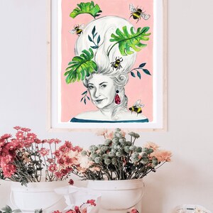 May include: A watercolor painting of a woman with a large, white, bouffant hairstyle adorned with green leaves and bees. The woman is wearing a blue and white striped shirt and a red earring. The background is a light pink.