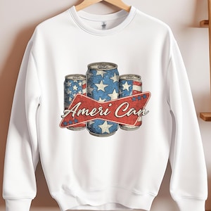 May include: White sweatshirt with a vintage-style graphic of three red, white, and blue cans with stars and the text "Ameri Can".