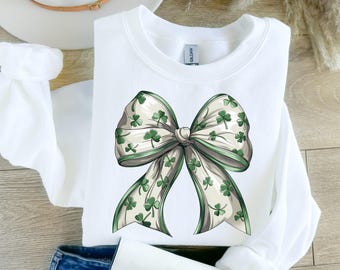 May include: White sweatshirt with a green and white shamrock bow on the front.