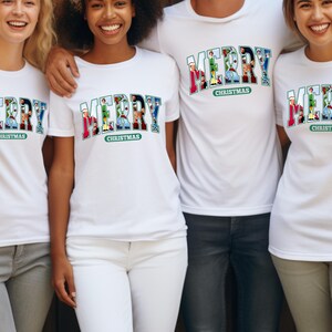 May include: Four people wearing white t-shirts with a colorful "Merry Christmas" graphic. The graphic is made up of small images of Christmas characters.