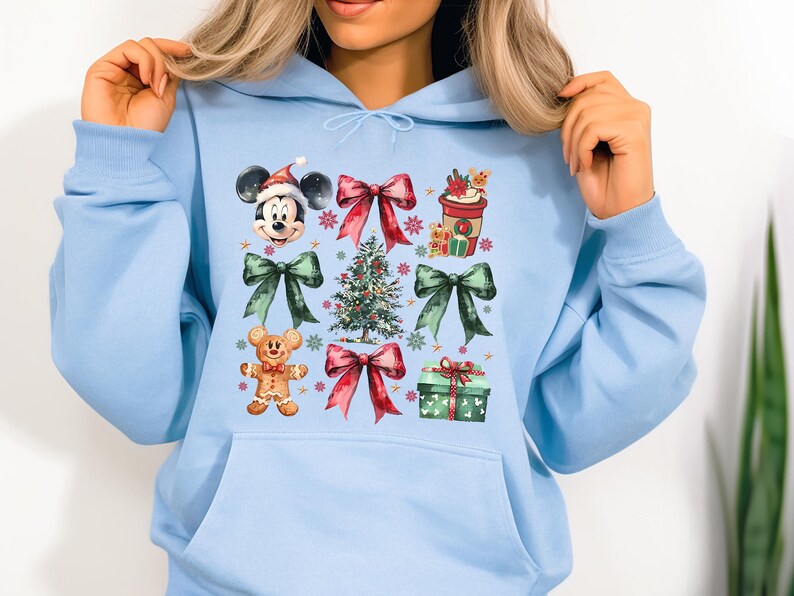 May include: Light blue hoodie with a Christmas-themed design featuring Mickey Mouse, a Christmas tree, bows, and gifts.