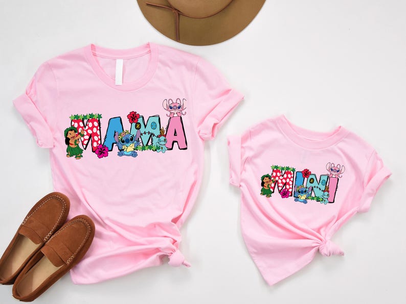 May include: Pink t-shirts with a "Mama" and "Mini" design featuring Stitch characters from Lilo & Stitch. The shirts have a floral and tropical theme.