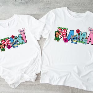 May include: Two white t-shirts with a blue and pink cartoon character design. The larger shirt says "MAMA" and the smaller shirt says "MINI".