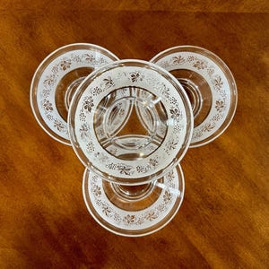 May include: Three clear glass bowls with a white grapevine design around the rim.