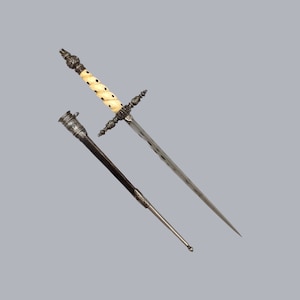 Puede incluir: Una daga de plata con mango de hueso blanco y una vaina a juego. La daga tiene un diseño decorativo en el mango y la hoja.