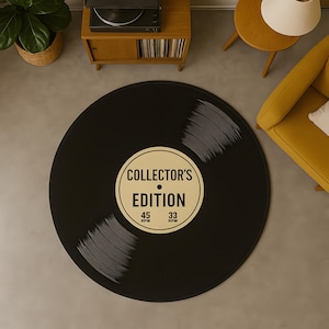 May include: A round black rug designed to resemble a vinyl record. The rug features a cream-colored label with the text "COLLECTOR'S EDITION" and the speeds 45 and 33 RPM. The rug is a decorative item for a living room or music room.