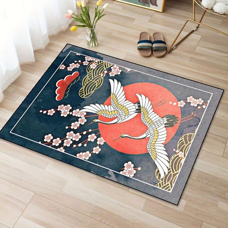 May include: A blue and red area rug with a white and yellow crane design. The rug features a stylized floral pattern and a red circle with a white and yellow crane design.
