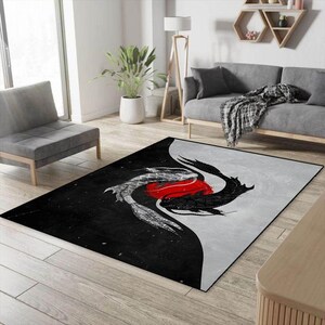 May include: Black and white area rug with a yin yang design featuring two stylized fish, one black and one white, with a red circle in the center.