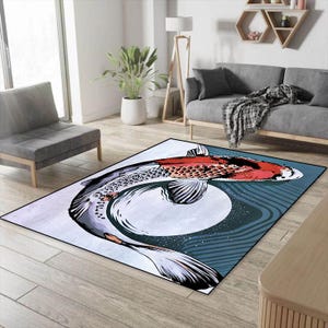 May include: A blue and white area rug with a large, colorful koi fish design. The rug has a circular pattern in the center and a wavy pattern around the edges.