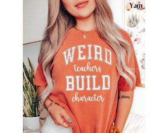 May include: A burnt orange t-shirt with the text "WEIRD teachers BUILD character" in white lettering.
