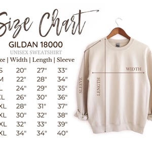Pu&ograve; includere: Una felpa unisex Gildan 18000 color crema appesa a una gruccia di legno. L'immagine include una tabella delle taglie con misure in cm per larghezza, lunghezza e lunghezza manica, dalla taglia S alla 5XL.