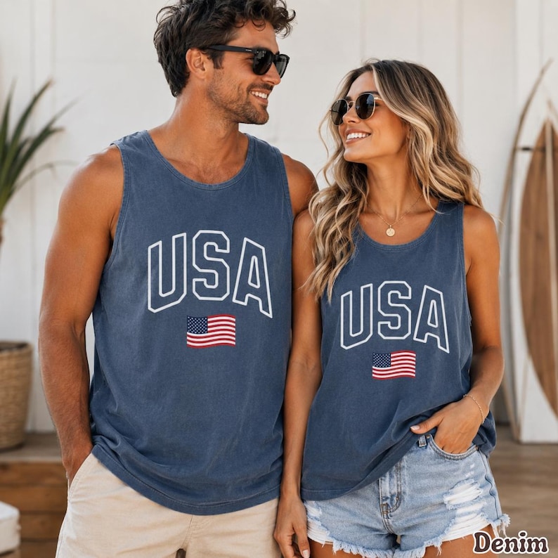Peut inclure: Deux d&eacute;bardeurs bleu denim assortis avec le mot "USA" en lettres blanches et un petit drapeau am&eacute;ricain. Les d&eacute;bardeurs sont sans manches et ont une coupe d&eacute;contract&eacute;e.