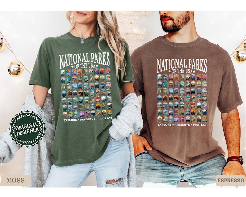以下が含まれることがあります： アメリカの国立公園のグラフィックプリントが施されたTシャツ2枚。シャツの色はモスグリーンとエスプレッソブラウン。シャツには「National Parks of the USA」と「Explore - Preserve - Protect」の文字が書かれています。