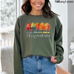 May include: A green sweatshirt with a watercolor design of colorful trees and the text "Fall is my favorite color" with a heart.