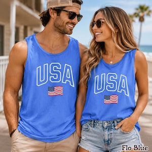 Peut inclure: Deux personnes portant des d&eacute;bardeurs bleus avec le mot "USA" en lettres blanches et un petit drapeau am&eacute;ricain. Les d&eacute;bardeurs sont d'un bleu vif, parfaits pour un th&egrave;me patriotique.