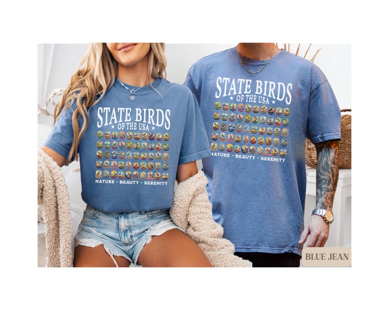 May include: Two people wearing blue t-shirts with a graphic of state birds of the USA. The text on the shirts reads "State Birds of the USA" and "Nature - Beauty - Serenity".