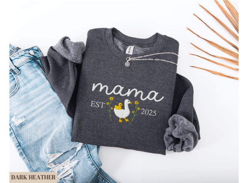 May include: Dark heather grey sweatshirt with the text "mama est. 2025" and an embroidered image of a duck and duckling.