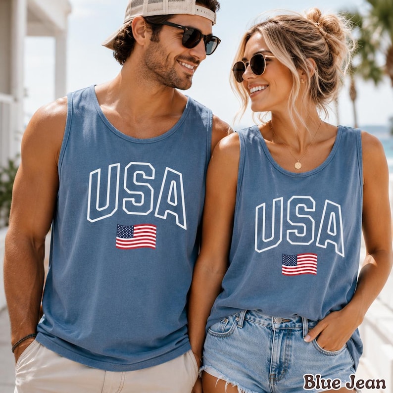 Peut inclure: Deux d&eacute;bardeurs bleus avec le mot "USA" en lettres blanches et un petit drapeau am&eacute;ricain. Les d&eacute;bardeurs sont port&eacute;s par deux personnes. Le texte "Blue Jean" est en bas &agrave; droite de l'image.
