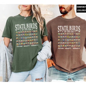 May include: Two t-shirts with a graphic print of the state birds of the USA. The text on the shirts reads "State Birds of the USA" and "Nature - Beauty - Serenity". The shirts are available in moss and espresso colors.