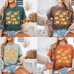 May include: Four t-shirts in different colors: blue spruce, espresso, bay, and yam. Each shirt features a square design with orange pumpkins and green leaves. The words "COMFORT COLORS" are printed on each shirt.