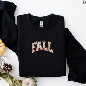 May include: Black sweatshirt with a fall-themed graphic that says "FALL" in a vintage style font.