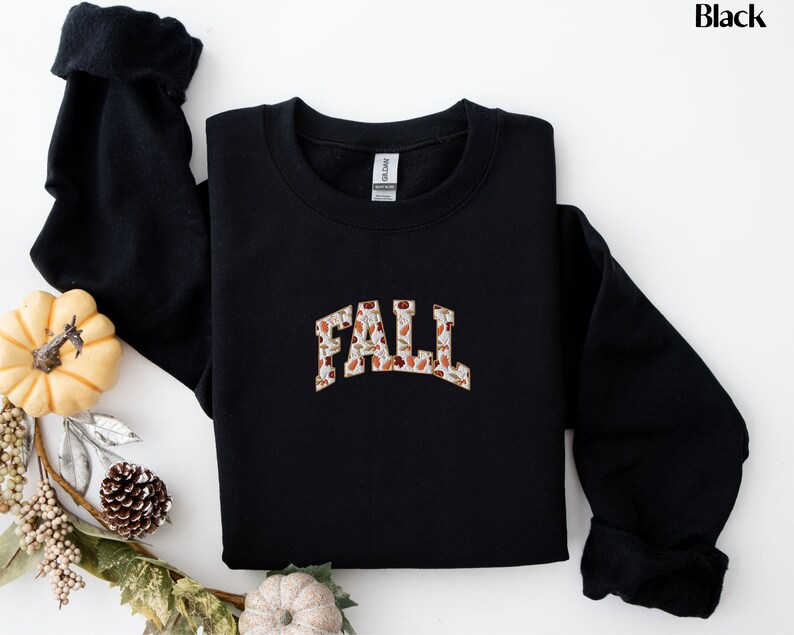 May include: Black sweatshirt with a fall-themed graphic that says "FALL" in a vintage style font.