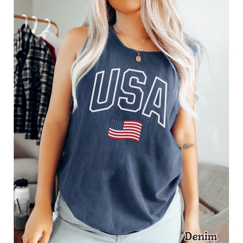 Peut inclure: Un d&eacute;bardeur bleu marine avec le mot "USA" en lettres blanches et un petit drapeau am&eacute;ricain. Le d&eacute;bardeur est fait d'une mati&egrave;re douce et a une encolure d&eacute;gag&eacute;e.