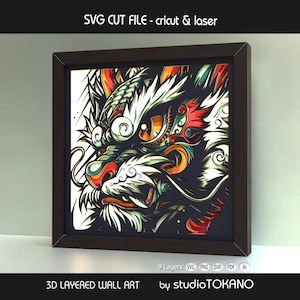 Puede incluir: Una obra de arte mural 3D en capas enmarcada con un diseño de dragón colorido. La obra de arte utiliza una variedad de colores, incluyendo rojo, naranja, blanco y verde. El marco es marrón oscuro. El texto en la parte superior dice "SVG CUT FILE - cricut & laser".