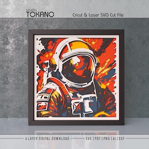 May include: A multi-layered wall art piece featuring a stylized astronaut in a helmet, rendered in vibrant shades of orange, yellow, blue, and white. The design includes the text studio TOKANO, Cricut & Laser SVG Cut File, and 6 LAYER DIGITAL DOWNLOAD.
